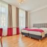 Hotel Unter den Linden Zimmer 104, © Hotel Unter den Linden Helles Hotelzimmer mit Doppelbett, Schreibtisch und Stuhl.