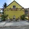Pilgerunterkunft, © Weinviertel Tourismus GmbH Gelbes Gebäude mit Pergola und Sitzbereich im Freien.