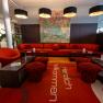 arte Hotel Krems, © Niederösterreich Werbung / Maximilian Pawlikowsky Moderne Hotellobby mit roten Möbeln und Kunstwerk an der Wand.