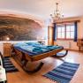 Zimmer Nr. 6 Schlittenbett, © Weingut Zöhrer Gemütliches Zimmer mit Schlittenbett, Holzmöbeln und großem Wandbild. Eine Weinflasche steht im Vordergrund.
