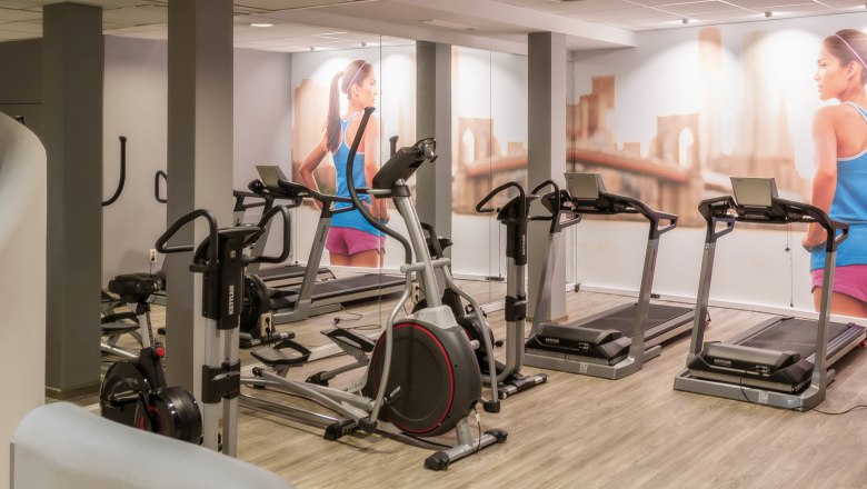 City Hotel Fitnessraum, © © Markus Jung, MJM Photography Fitnessraum mit Laufbändern und Fitnessgeräten, Wandbild einer Frau beim Laufen.