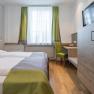 Hotel Unter den Linden E09, © Hotel Unter den Linden Modernes Hotelzimmer mit Doppelbett, Schreibtisch und Fernseher.