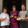 Wein.Restaurant Neustifter, © Weinviertel Tourismus / Michael Reidinger Drei Personen vor einem Restaurant, eine Frau mit Weinglas, eine Frau mit Weinflasche, ein Mann im Kochoutfit mit Teller.