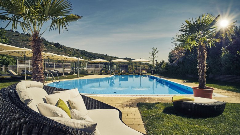 Steigenberger Krems, Außenpool, © Steigenberger Hotel and Spa, Andreas Hofer Außenpool des Steigenberger Krems mit Liegestühlen und Sonnenschirmen.