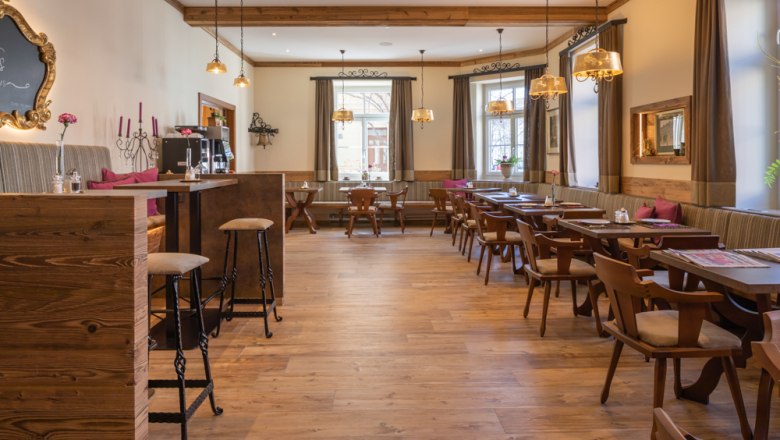 Gaststube Frühstücksbereich, © Hotel Unter den Linden Gemütlicher Frühstücksbereich mit Holzmöbeln und großen Fenstern.