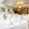 Wintergarten Restaurant, © flotographix Der Wintergarten mit einem gedeckten Tisch und weißen Stühlen.