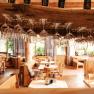 Wein.Restaurant Neustifter, © Weinviertel Tourismus / Michael Reidinger Innenansicht eines Restaurants mit hängenden Weingläsern und Holzmöbeln.