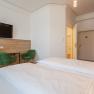 Hotel Unter den Linden 206, © Hotel Unter den Linden Hotelzimmer mit Doppelbett, grüne Stühle, Schreibtisch und Fernseher.