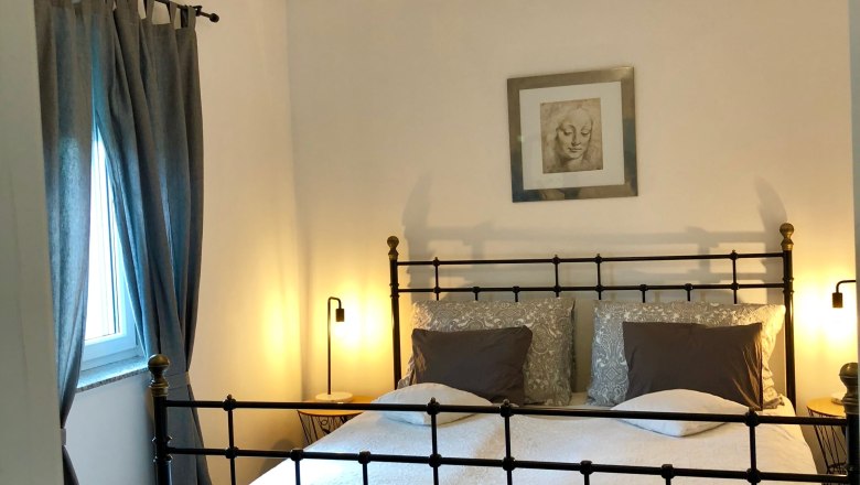 Jednodu&scaron;e zař&iacute;zen&aacute; ložnice s postel&iacute; a klidnou atmosf&eacute;rou.