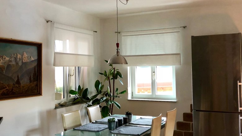 Otevřen&yacute; ob&yacute;vac&iacute; a j&iacute;deln&iacute; prostor se stolem, židlemi a přirozen&yacute;m světlem.