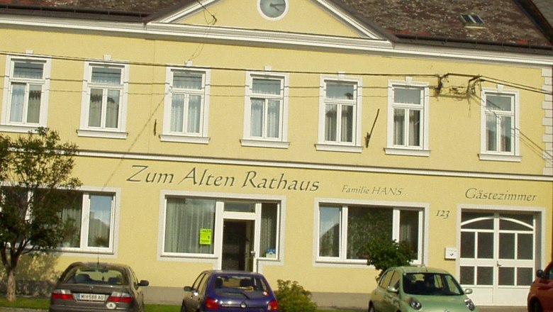 Gelbes Gebäude mit der Aufschrift 'Zum Alten Rathaus', Autos parken davor.