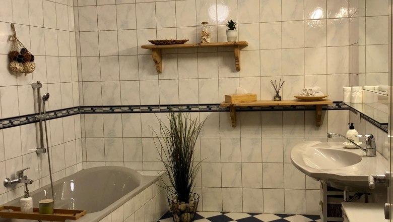 Modern&iacute; koupelna se sprchov&yacute;m koutem, umyvadlem a světl&yacute;m designem.