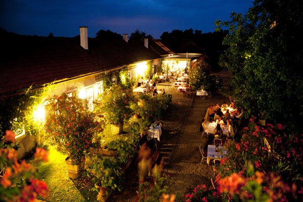 Evening garden terrace with illuminated tables and plants.