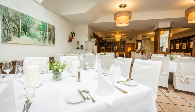 The winter garden with a set table and white chairs.
