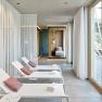 Moderner Spa-Bereich mit Liegest&uuml;hlen und gro&szlig;en Fenstern.
