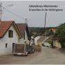 Malebn&aacute; ulice s tradičn&iacute;mi domy a n&aacute;ves&iacute;. V pozad&iacute; je vidět hrad na kopci.