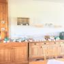 Frühstücksbuffet auf einem Holzbuffet mit Geschirr, Gläsern und einer Kaffeemaschine.