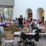 Menschen sitzen in einem Innenhof an Tischen und essen.