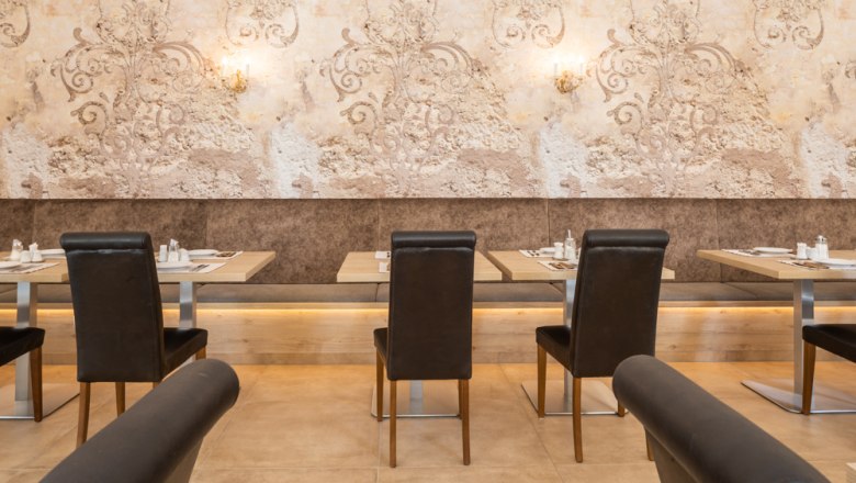 Ein elegantes Restaurant mit gedeckten Tischen und stilvoller Wanddekoration.