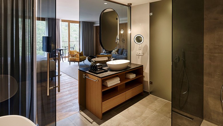 Modernes Hotelzimmer mit offenem Bad und Dusche.