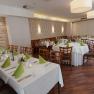 Elegantes Restaurant mit gedeckten Tischen und grünen Servietten.