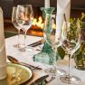 Elegante Tischdekoration mit Gläsern, Kerzenhalter und Blumen im Steigenberger Krems Restaurant.