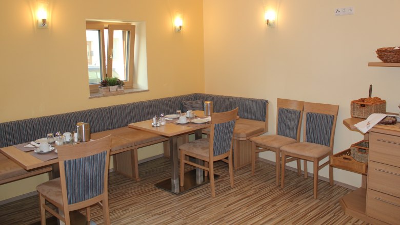Cozy breakfast room with wooden furniture and table setting.