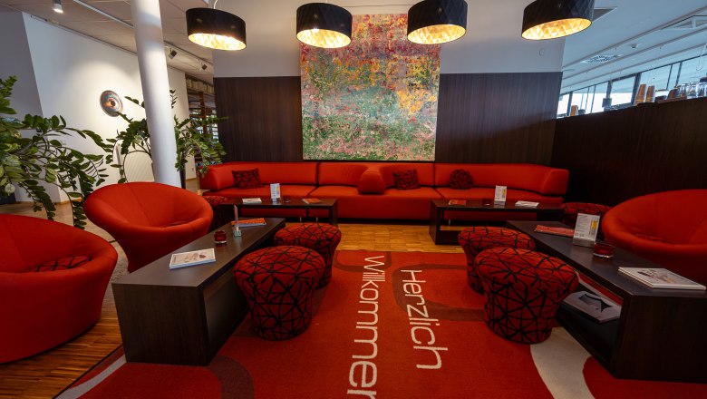 Moderne Hotellobby mit roten Möbeln und Kunstwerk an der Wand.