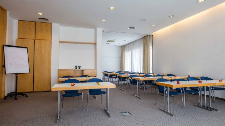 Semin&aacute;rn&iacute; m&iacute;stnost se stoly, židlemi a jablky na stolech.