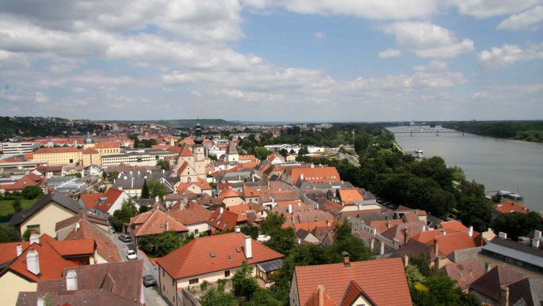 Panoramablick auf die Dächer von Krems mit Fluss und Brücke im Hintergrund.
