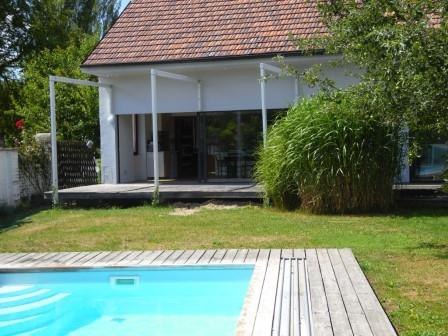 A modern house with terrace and pool in the garden.