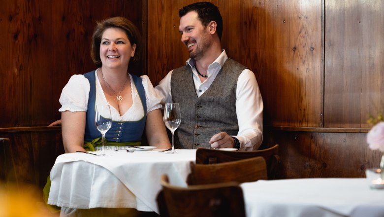 Lächelndes Paar in traditioneller Kleidung in einem Restaurant.