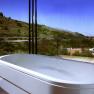 Panoramablick aus einem Badezimmer mit Badewanne und Blick auf Weinberge.
