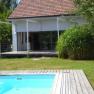 A modern house with terrace and pool in the garden.