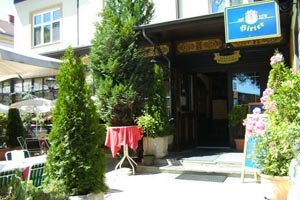 Vchod do restaurace s rostlinami a n&aacute;pisy.