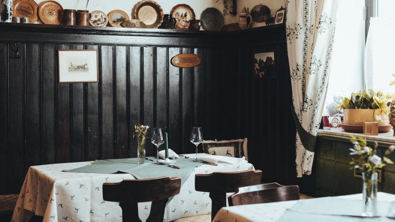 Cozy restaurant with wooden walls and decorated tables.