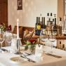 Eleganter Tisch in Hotel-Restaurant mit Weingl&auml;sern, Kerze und Blumen.