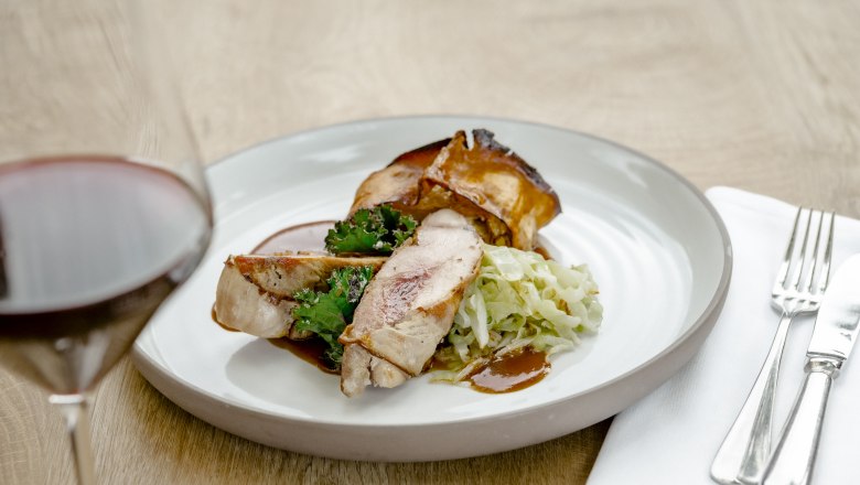 Tal&iacute;ř s bažant&iacute;mi prs&iacute;čky, kapustou a zel&iacute;m a vedle sklenka červen&eacute;ho v&iacute;na.