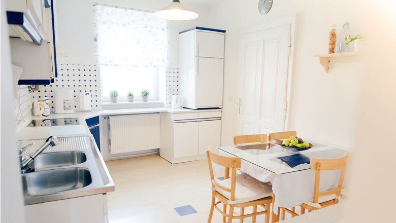 Bright kitchen with dining table, chairs and modern appliances.