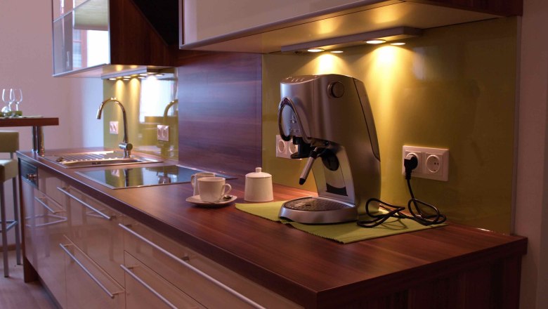 Moderne Küche mit Kaffeemaschine und Spüle.