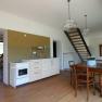 Interior view of a living room with kitchen, dining table and staircase.